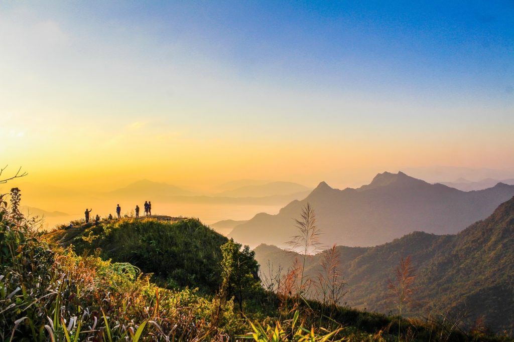 Mountain landscape with people at sunrise.